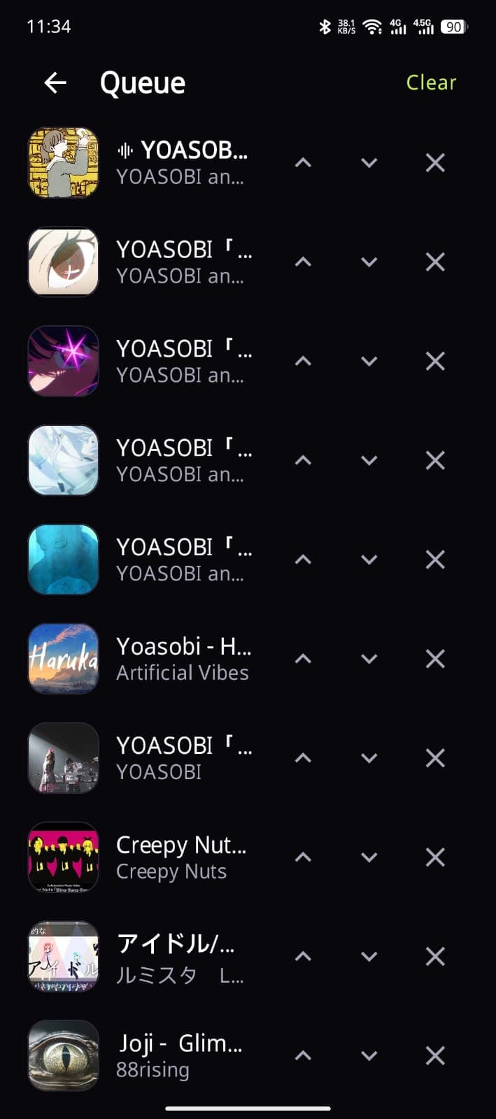 Queue screen listing ten upcoming tracks, the playing one marked with a waveform icon, each row with controls to move it up, down, or remove it
